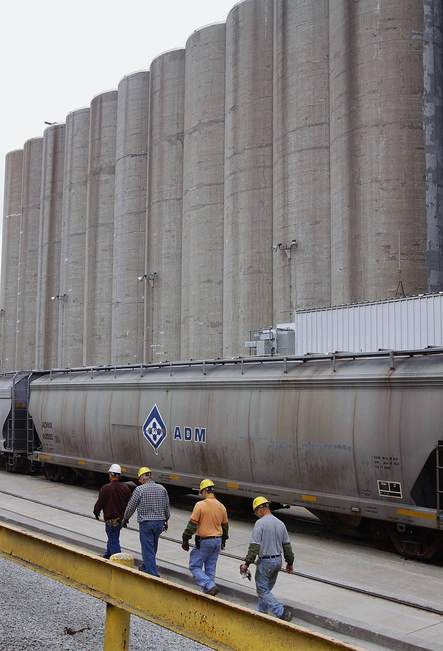 Archer Daniels Midland workers walk along the grain silos next to the rail car tracks at the ADM plant in Decatur in central Illinois.