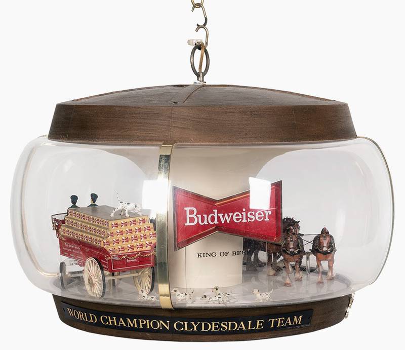 This advertising lamp includes figures of a team of horses pulling a beer cart, followed by a crowd of Dalmatians. The lamp with a moving wagon sold for $625.