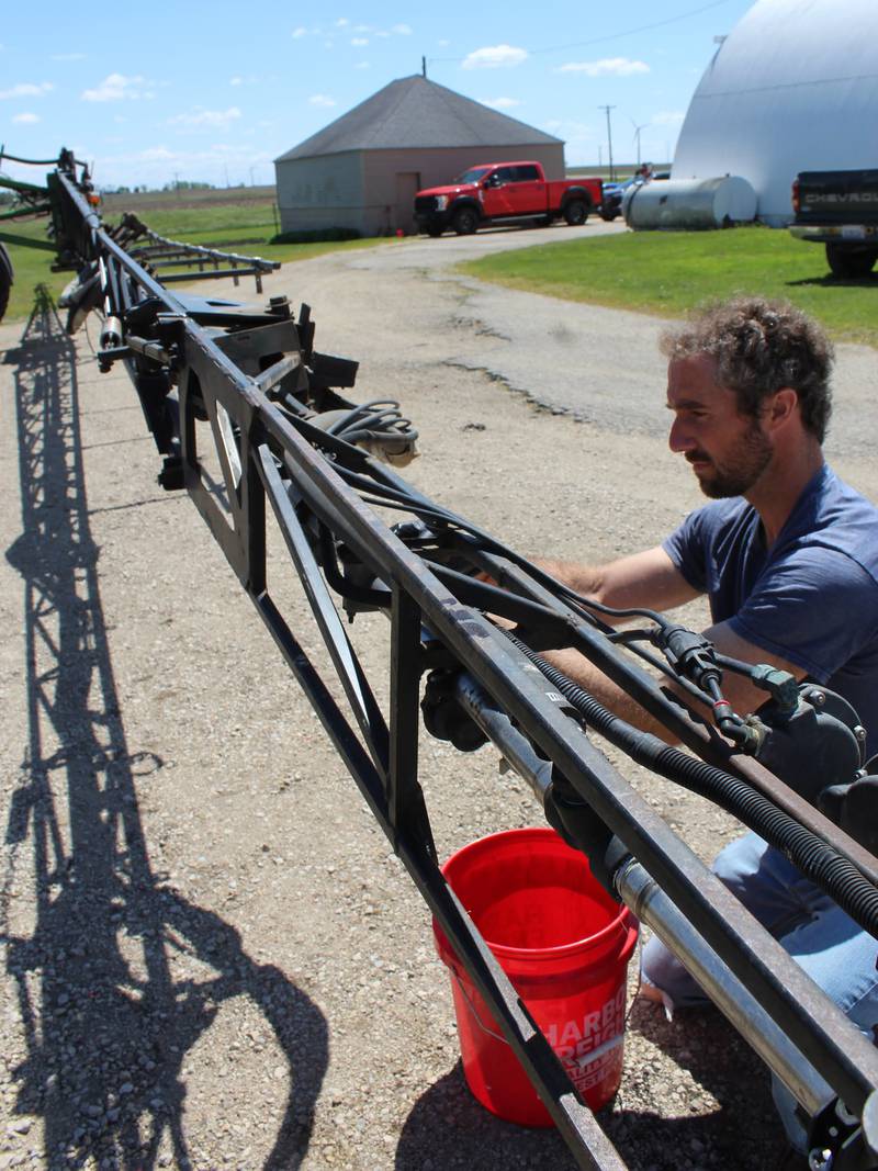 Brandon Wessels works on his sprayer in preparation for applying pre-emerge herbicide on the fields of recently planted soybeans. Planting of both corn and soybeans was completed on May 8.