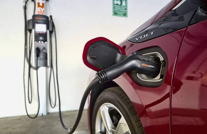 A Chevrolet Volt hybrid car is seen charging at a ChargePoint charging station at a parking garage in Los Angeles.