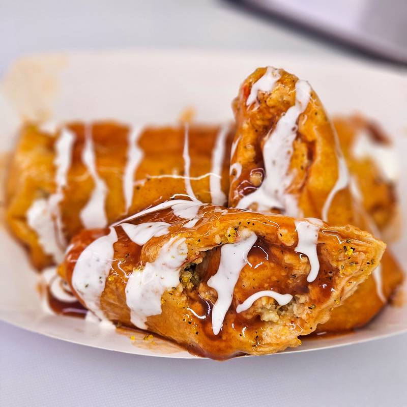 Dirty Dancing Egg Rolls by Taste of Home Catering and Food Truck. Two, four inch chicken Philly egg rolls dipped in a homemade hot honey lemon pepper buffalo sauce drizzled with ranch dressing.