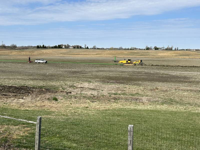 A farmer lays tile in a field in Johnson County, Indiana.