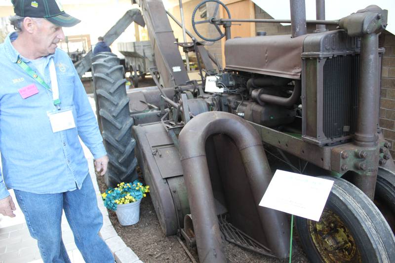 Brad Mundt talks about the 1936 John Deere B with the No. 15 Cotton Stripper that was on display at the Gathering of the Green event. Collectors from 10 states brought equipment to display during the four-day conference.