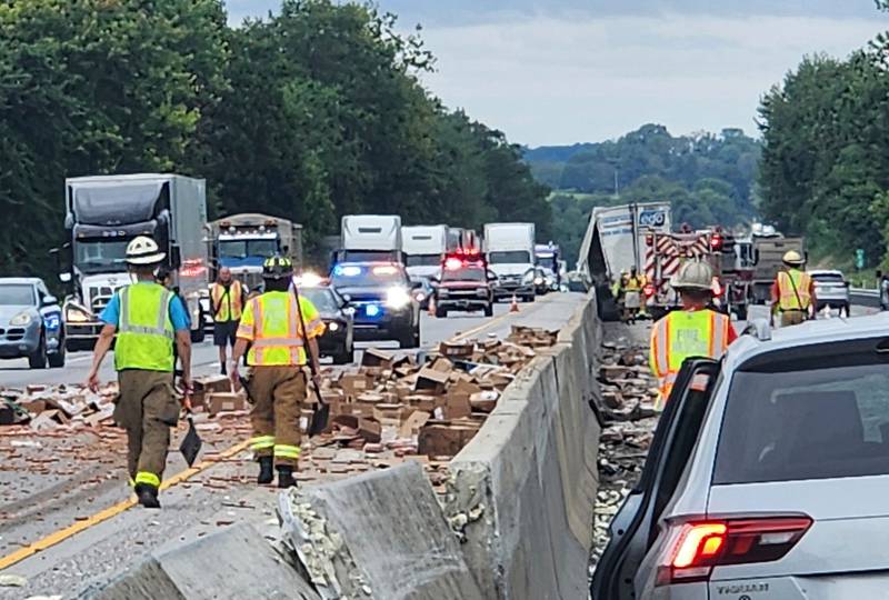 Rescue crews clean up a truckload of hot dogs that spilled out of a tractor-trailer on Aug. 1, along Interstate 83 in Shrewsbury, Pennsylvania.