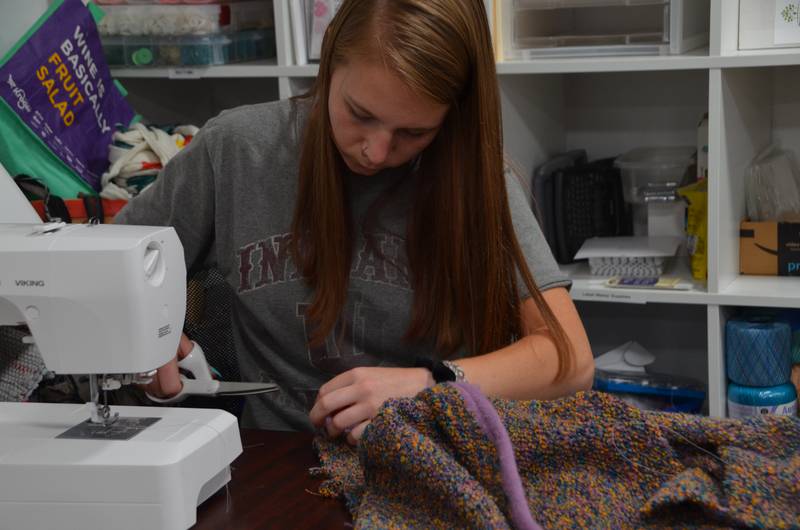 A member of Watch Us Farm learns to make handmade goods that will later be sold.