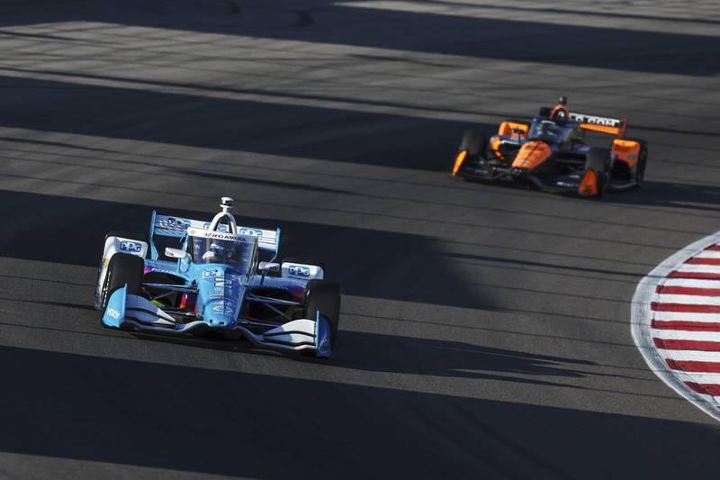 Josef Newgarden, left, drives during an IndyCar auto race on Saturday, Aug. 17, 2024, at World Wide Technology Raceway in Madison, Ill.