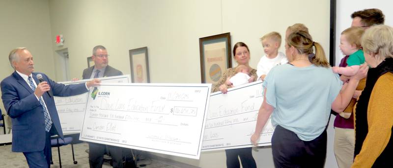 Rodney Weinzierl (left), IL Corn executive director, presented scholarships for Dave Loos' grandchildren at the Illinois Corn Growers Association annual meeting. The scholarships are through contributions from farmers, state corn organizations, the ethanol industry and others in honor of Loos for his three decades of work promoting ethanol and the corn industry.