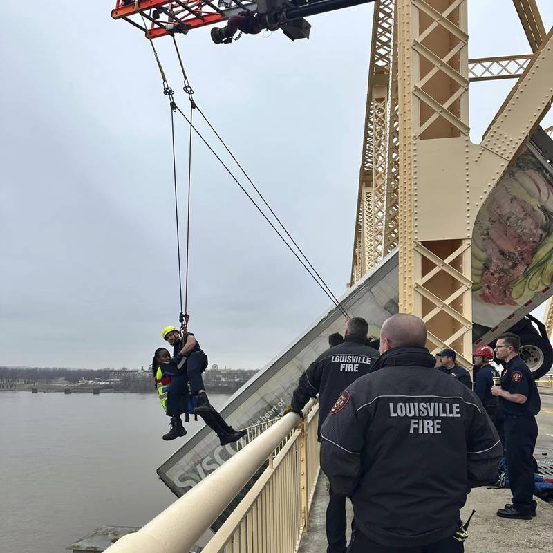 Firefighter Bryce Carden rescues the driver of semitruck that is dangling off the Clark Memorial Bridge over the Ohio River on March 1 in Louisville, Kentucky.