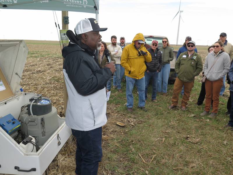 AGRINEWS PHOTO/TOM C. DORAN
Shalamar Armstrong, Purdue University associate professor of agronomy, details the decade of research on cover crops, nitrogen management, and crop production in tile-drained fields during the From Farm to Filtration: A Tour of Conservation in Action. The tile water leaving the field is measured for nitrate nitrogen and phosphorous in the automatic sampler behind Armstrong.