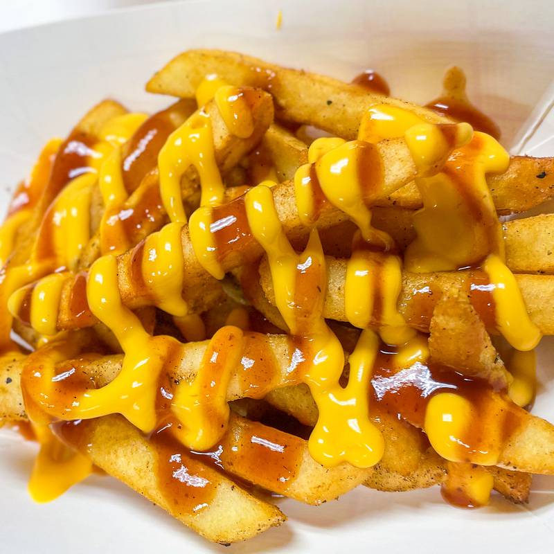 Jerk Cheesy Fries by Jamaican Breeze. The fries are crispy, cheesy and drizzled in your choice of mild or spicy jerk sauce — flavor that hits every time.