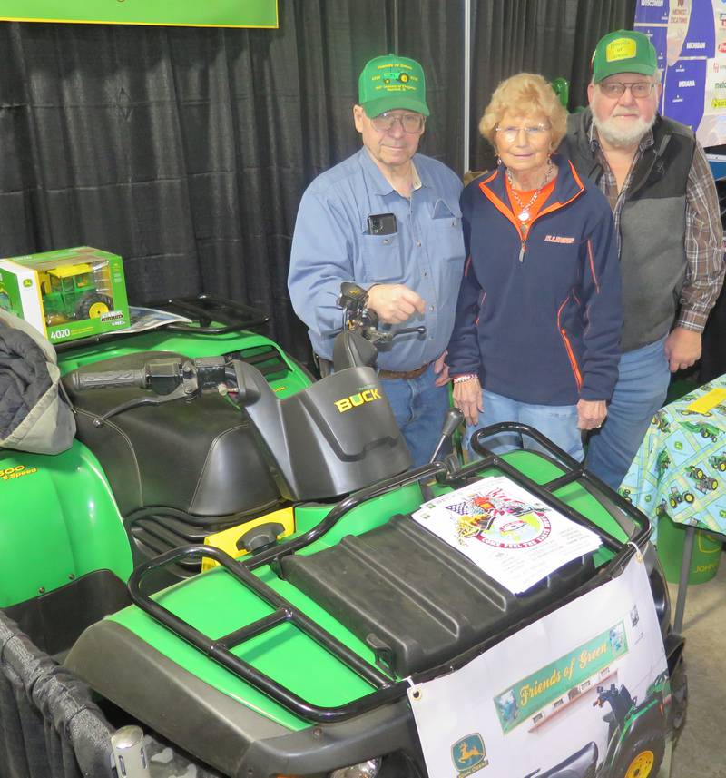 A 2006 John Deere Buck ATV is the grand prize in the annual Friends of Green Club’s benefit. Standing next to the ATV at the Midwest Ag Expo booth are Ed Winkelman (from left), Friends of Green president; Jane Piatt, treasurer; and Russ Tjarks, benefit co-chair. Chris Elliott, Friends of Green secretary, also assisted at the booth.