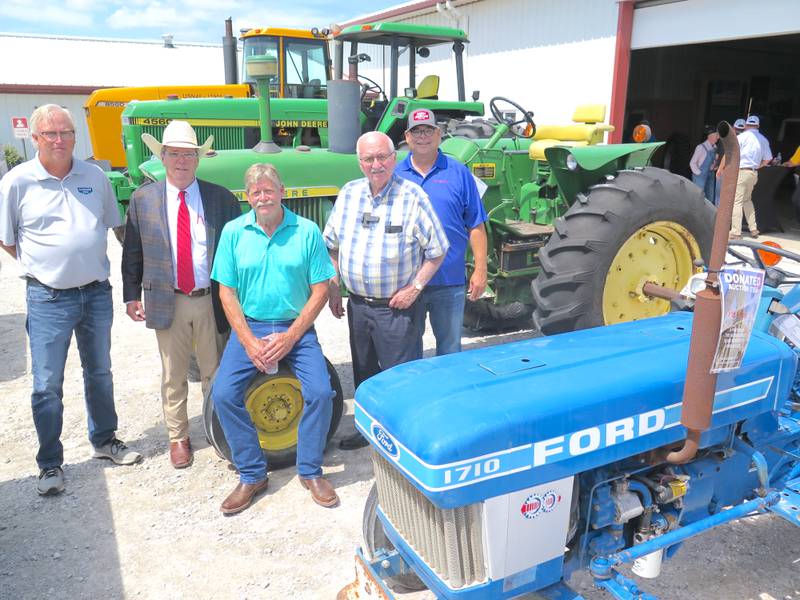Greg Peterson (from left), Machinery Pete; Dan Sullivan, Sullivan Auctioneers; George Braaksma, one of the sellers; Jon Kinzenbaw, Kinze Manufacturing; and Terry Johnston, Farm Rescue, are surrounded by tractors and trucks that will be sold at the BigIron/Sullivan auction during the Farm Progress Show Aug. 27. The 1986 Ford 1710 in the foreground was donated by John and Joan Sullivan to benefit Farm Rescue. The tractors behind the dignitaries include a 1972 John Deere 4000, 1994 John Deere 4560 and 1989 John Deere 8560 “U.S. Navy” tractor.