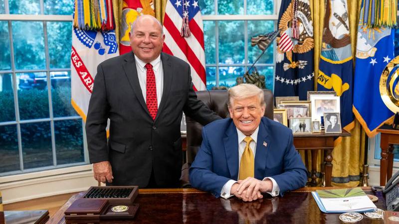 Zippy Duvall, American Farm Bureau Federation president, poses with U.S. President Donald Trump as he sits at the Resolute desk in the Oval Office.