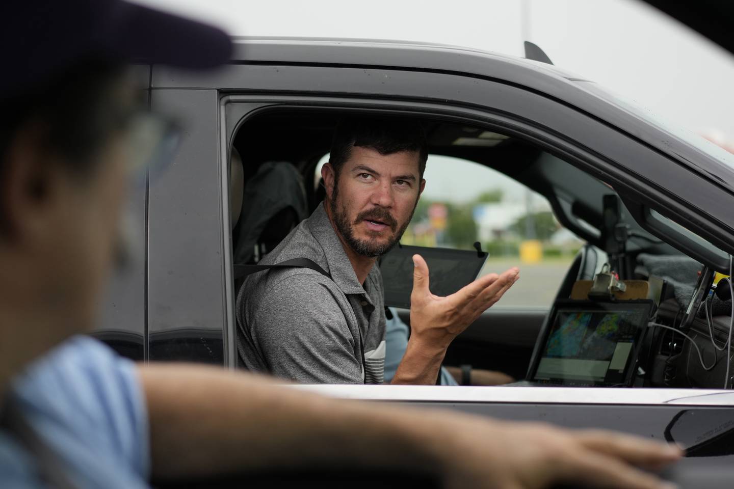 Victor Gensini, Northern Illinois University meteorology professor and a lead scientist of Project ICECHIP, speaks with Seth Borenstein, Associated Press science writer, as they stage in a Walmart parking lot before a Project ICECHIP operation in Atlus, Oklahoma.