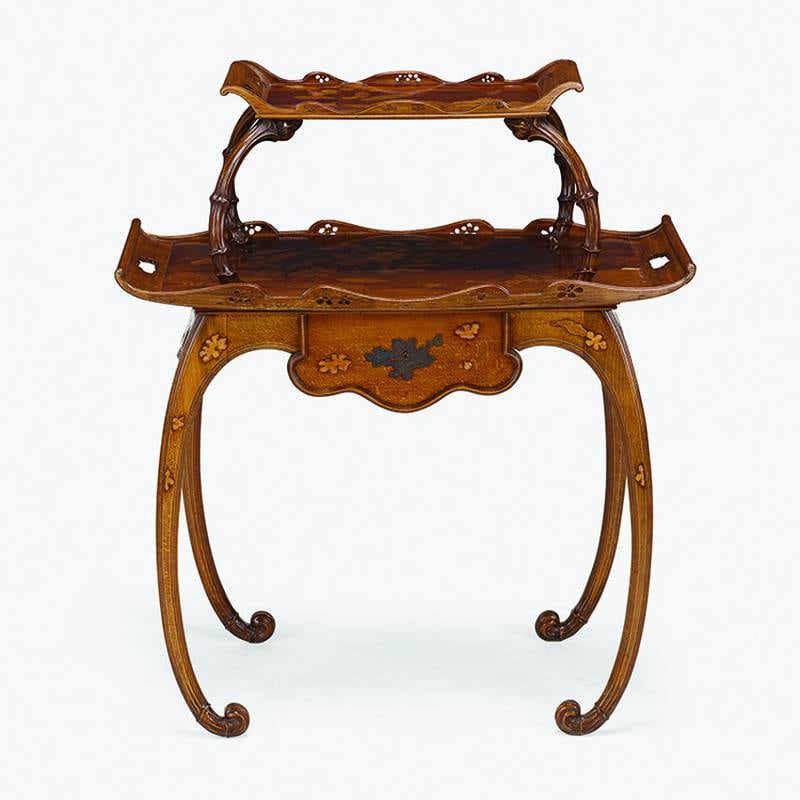 A wooden table like this one is as different as can be from a glass vase or a pottery figure, but Emile Galle brought his skill and art nouveau style to all three.