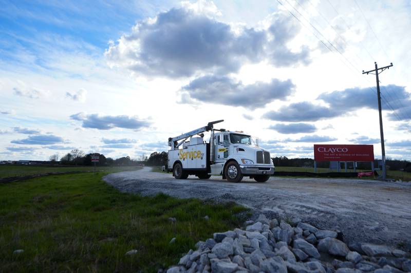 A truck leaves the site of a planned Rivian electric truck plant in Rutledge, Georgia. Rivian says it’s pausing construction of the $5 billion manufacturing plant.