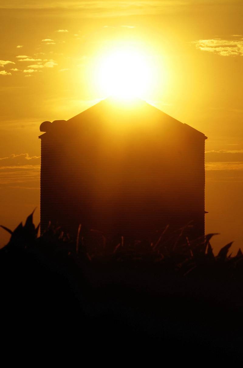 The sun rises over a grain silo in Ashland, Illinois.