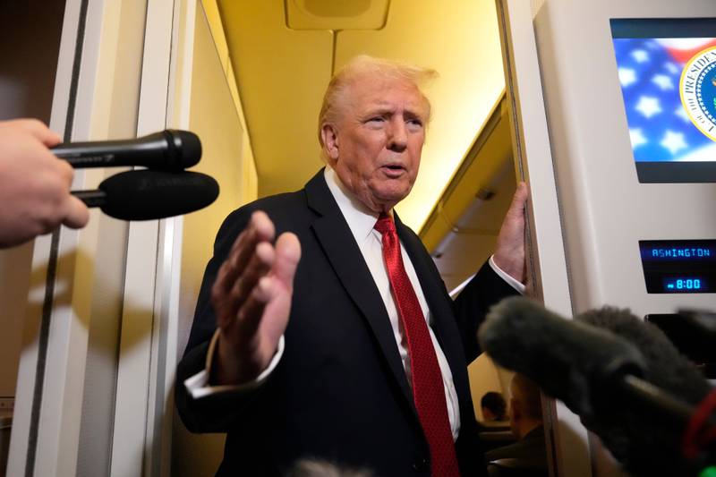 President Donald Trump speaks to reporters aboard Air Force One on Oct. 19 as he returns from a trip to Florida.