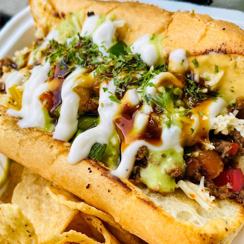 All Vegan Indianapolis Philly by Black Leaf Vegan Food Truck. Hoosier flavor, Philly soul and plant-based power. Introducing the All-Vegan Indianapolis Philly - stacked with grilled delicious plant-based meat, sautéed peppers and onions, and smothered in a creamy “cheez” sauce, all on a toasted hoagie.