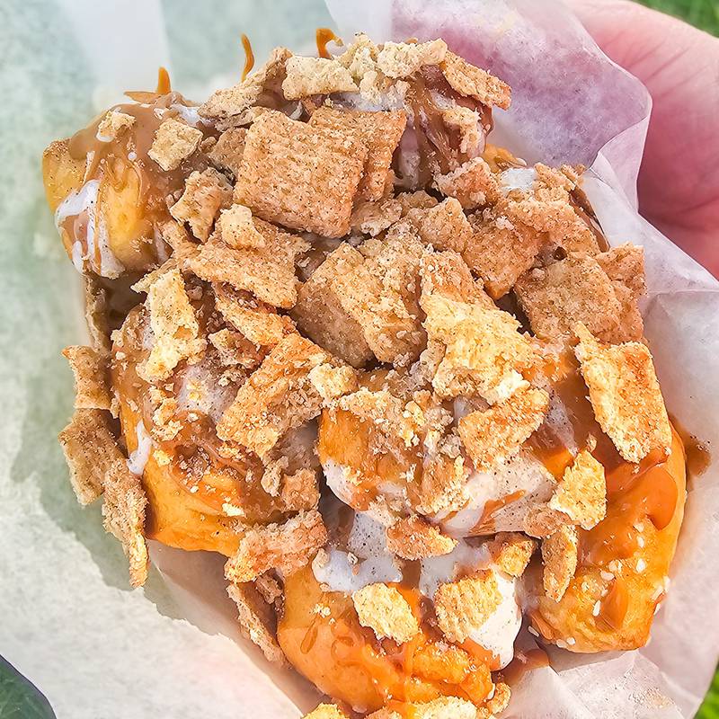 Cinnamon Toast Cookie Butter Pretzel Bites by Wilson Concessions. Pretzel bites covered in cinnamon and sugar then smothered with cookie butter, cream cheese icing and topped off with Cinnamon Toast Crunch cereal.