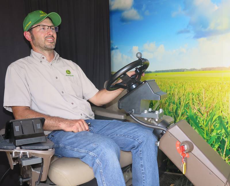 Russell Neu, Lake Land College’s John Deere technology program coordinator, demonstrates the mobile simulator at Historic Farm Days. Visitors could be in the driver’s seat to maneuver a myriad of John Deere equipment.