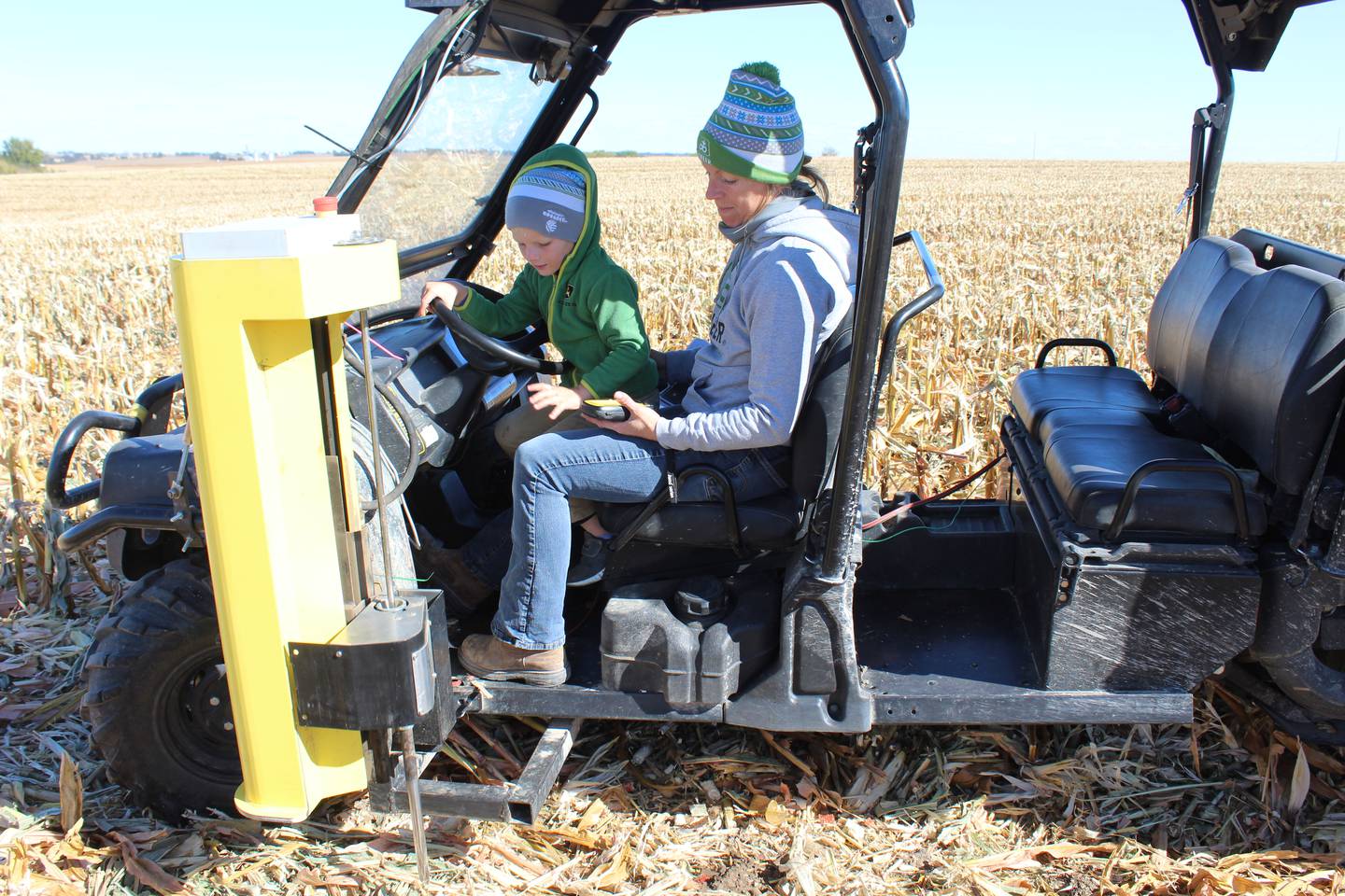 Kellie Rahn and her son, Anthony, take a soil test with a hydraulic probe. She uses a GPS handheld to locate each soil test point and takes six cores per point to get the core sample.