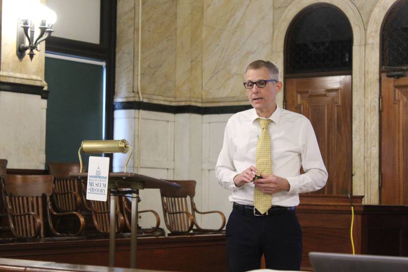 Bill Kemp talks about how cattle and hog farmers drove animals to markets and packing plants before the railroad system was established to transport livestock. The librarian at the McLean County Museum of History spoke in the courtroom of the former county courthouse.
