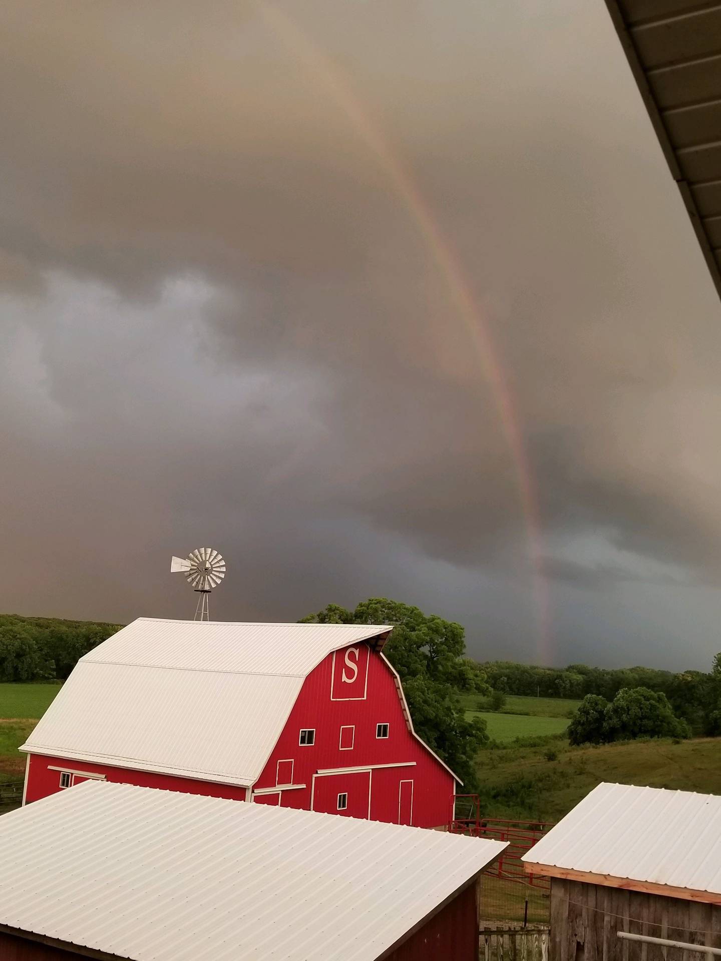“Favorite farm photo” — Rodney Seaton: “Even a rainbow still shines over the windmill and barn on a cloudy day.”