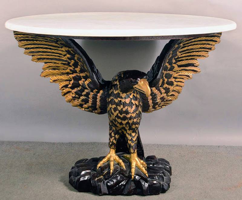 Eagles are a powerful symbol in American designs from the Great Seal to everyday decorative arts. A carved eagle holds up this table's faux marble top.
