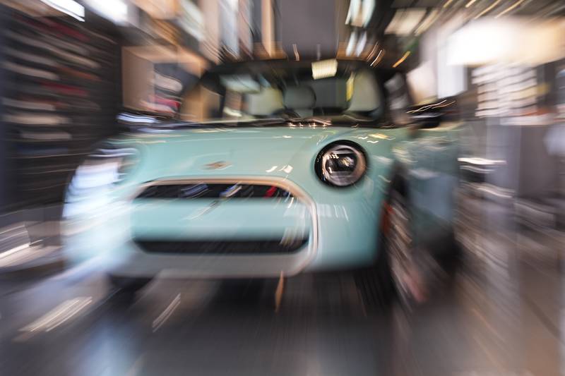 Made with a slow shutter speed and zoom lens, an unsold 2026 Cooper S hardtop is diplayed in a Mini dealership.
