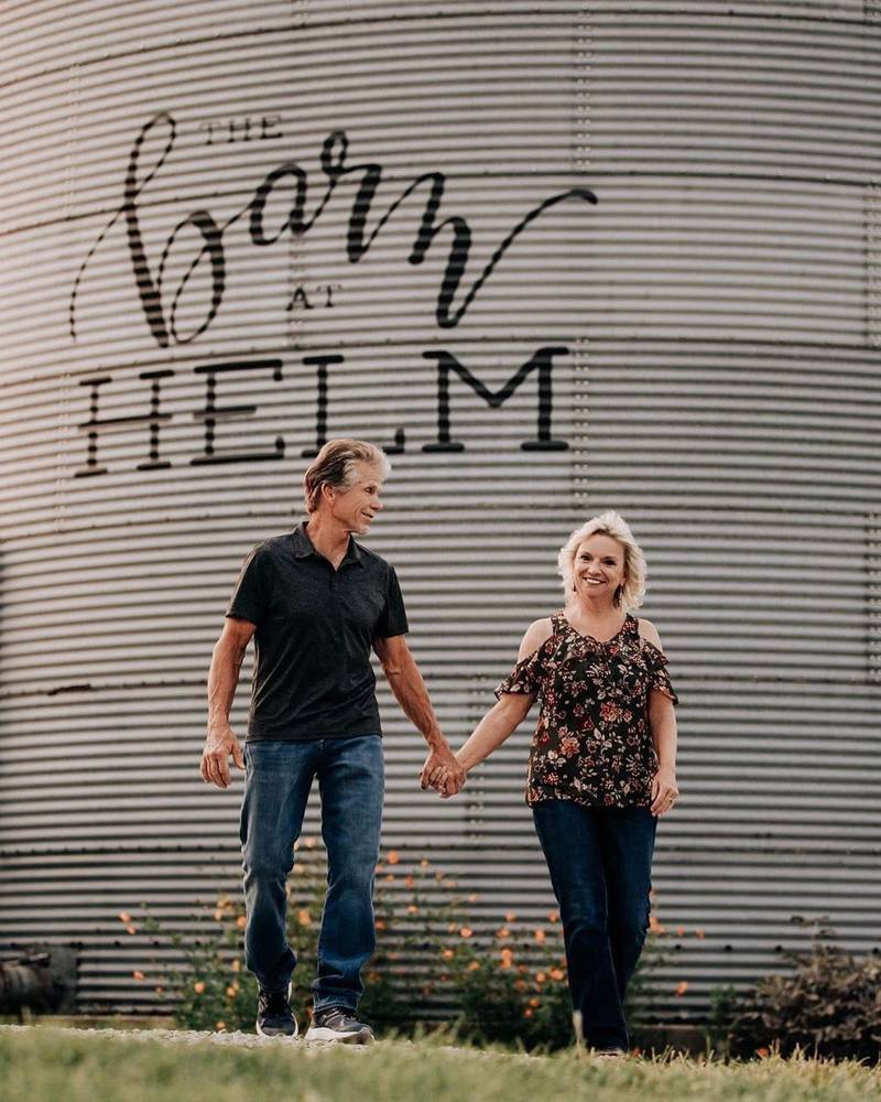 Tim and Julie Frame stand in front of a grain silo on their farm, the Barn at Helm, in Wayne County in east-central Indiana.