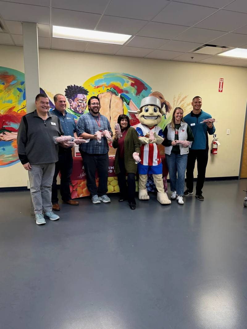 Indiana Pork farmer and board president Mark Johnson (second from left) is joined by members of the Community Harvest Food Bank and Johnny TinCap, Fort Wayne TinCaps mascot, to make a ground pork donation to the food pantry.