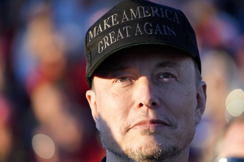 Tesla and SpaceX CEO Elon Musk listens as Republican former President Donald Trump speaks at a campaign event at the Butler Farm Show in Butler, Pennsylvania.