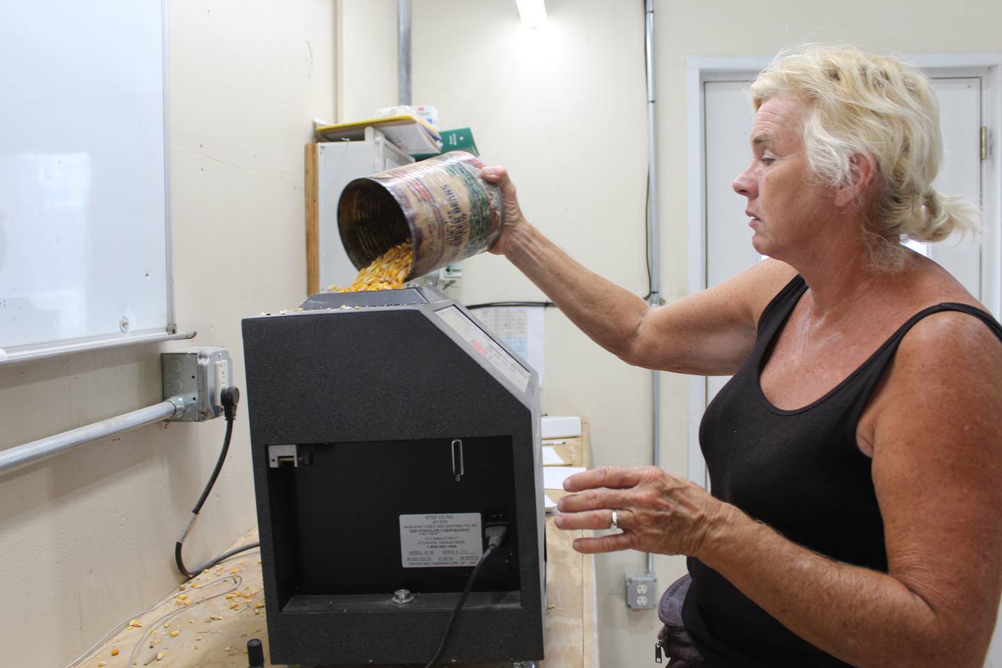 Annette Rahn pours corn into the moisture tester at the farm’s grain handling facility. The 104- and 105-day corn was testing at 25% moisture on Sept. 19.